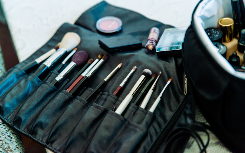 Set of professional PMU tools and brushes arranged neatly beside a practice latex sheet